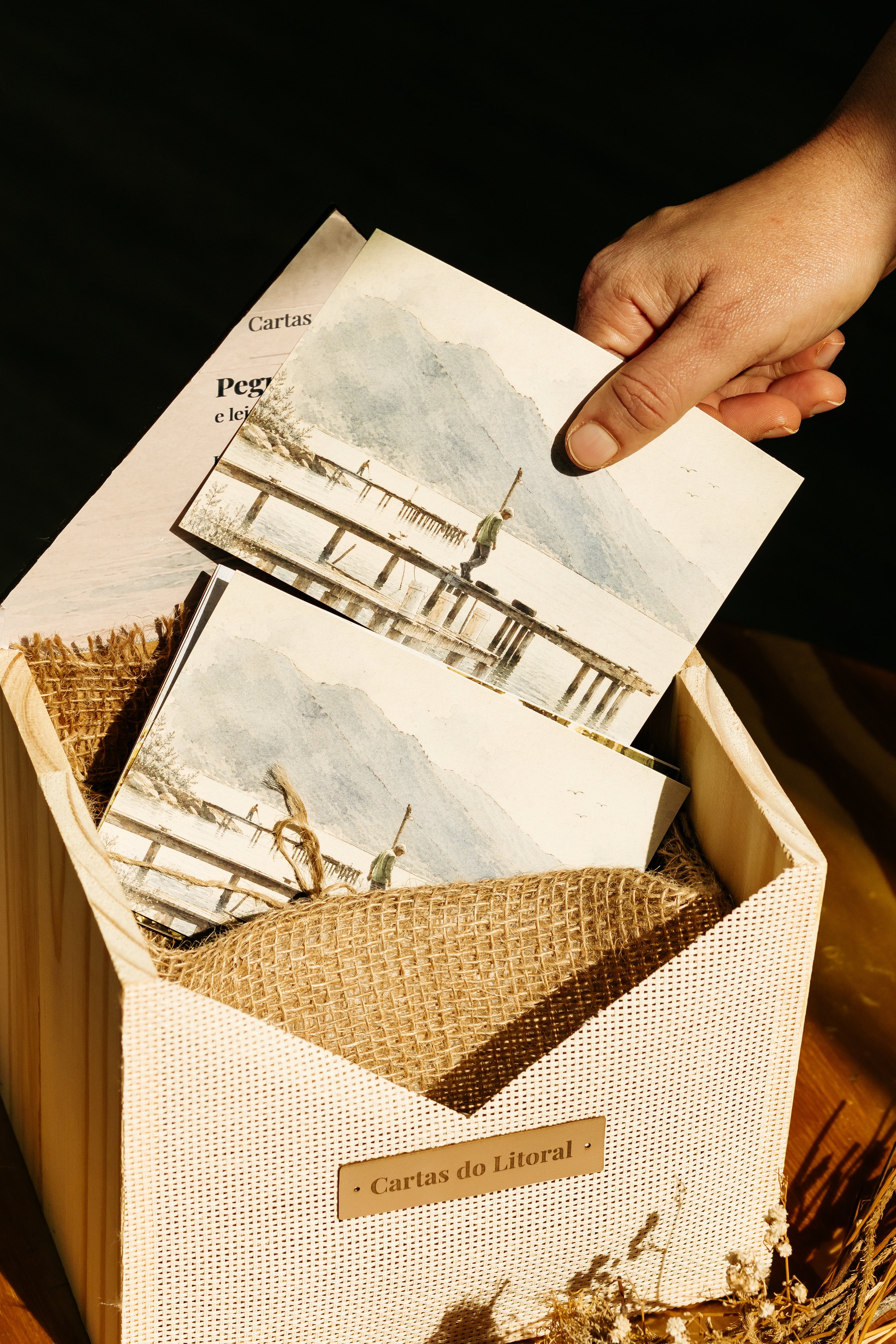 Display físico de Cartas do Litoral com materiais impressos.